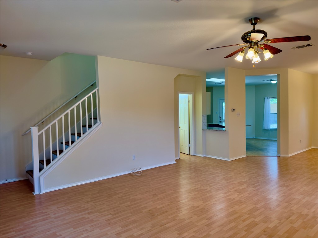 1206 Devil Ridge Cedar Park, TX 78613 - Photo 17 of 38 Unfurnished living room featuring light wood-style flooring, a ceiling fan, and stairs