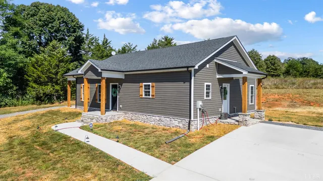 a view of a house with wooden fence next to a yard