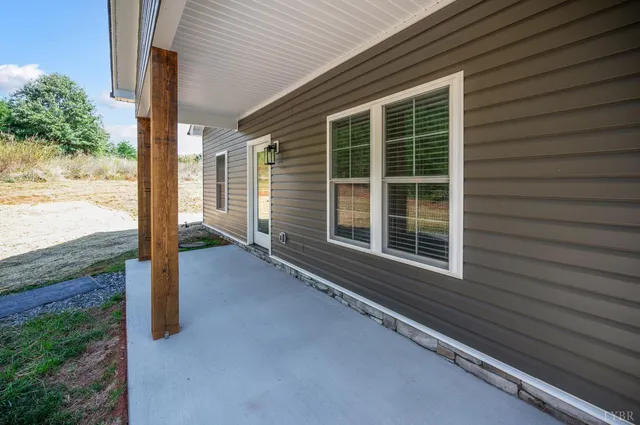 a view of a house with a floor to ceiling window and wooden fence