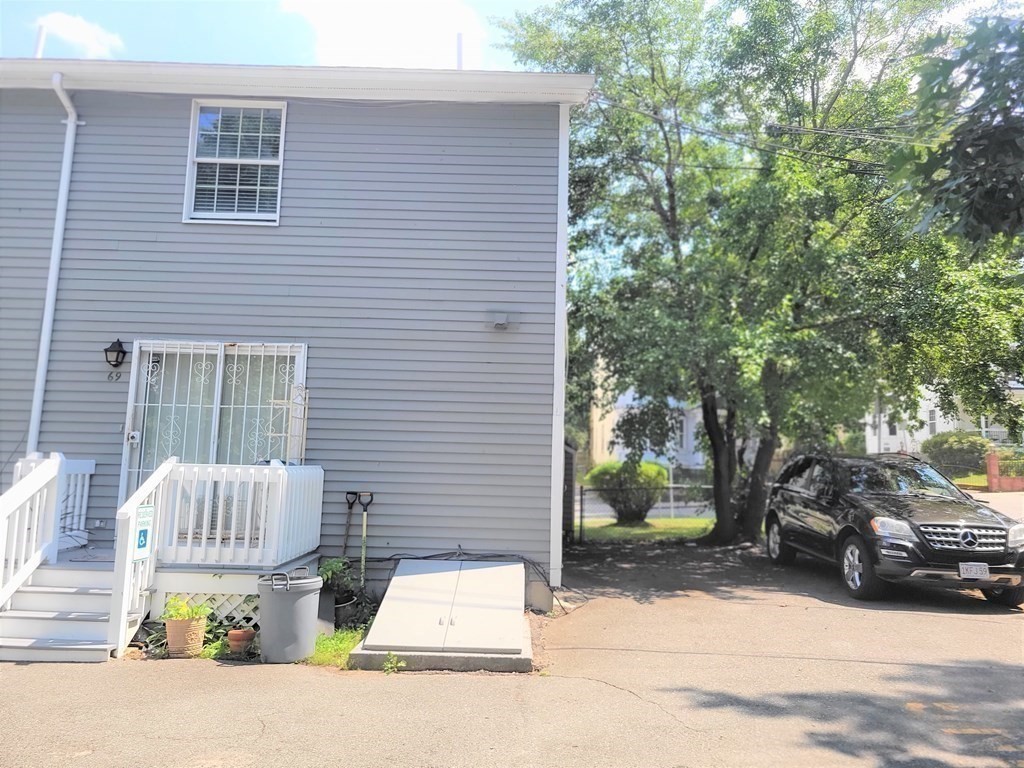 69 Fuller Street, Unit 69 Boston, MA 02124 - Photo 14 of 18 a view of a brick house with a chairs and table in a patio