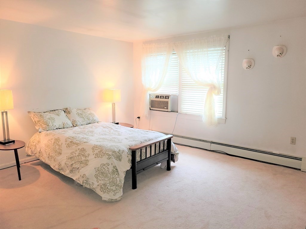 69 Fuller Street, Unit 69 Boston, MA 02124 - Photo 3 of 18 a spacious bedroom with a bed and a window