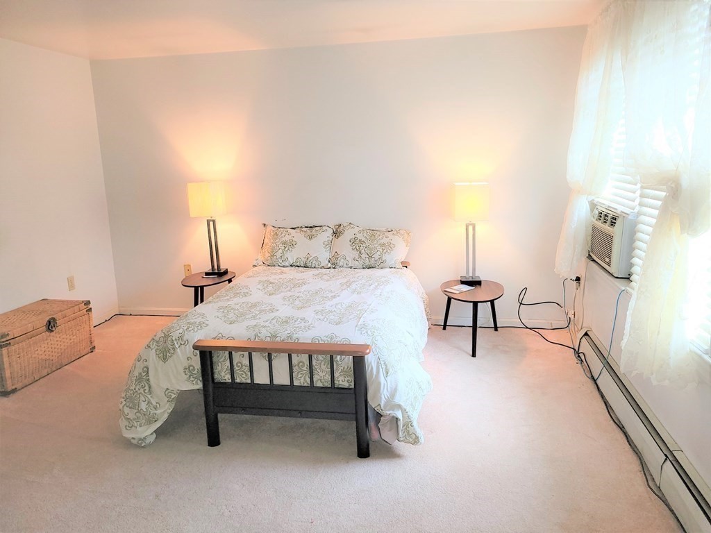 69 Fuller Street, Unit 69 Boston, MA 02124 - Photo 4 of 18 a bedroom with a bed and a table