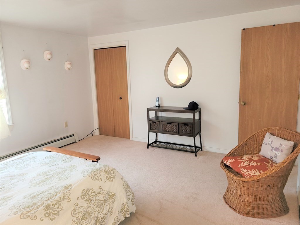 69 Fuller Street, Unit 69 Boston, MA 02124 - Photo 5 of 18 a bedroom with a bed and a chandelier