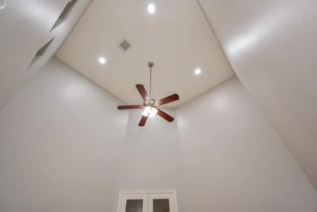 a room with ceiling fan and window