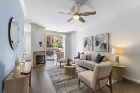 a living room with furniture a fireplace and a large window