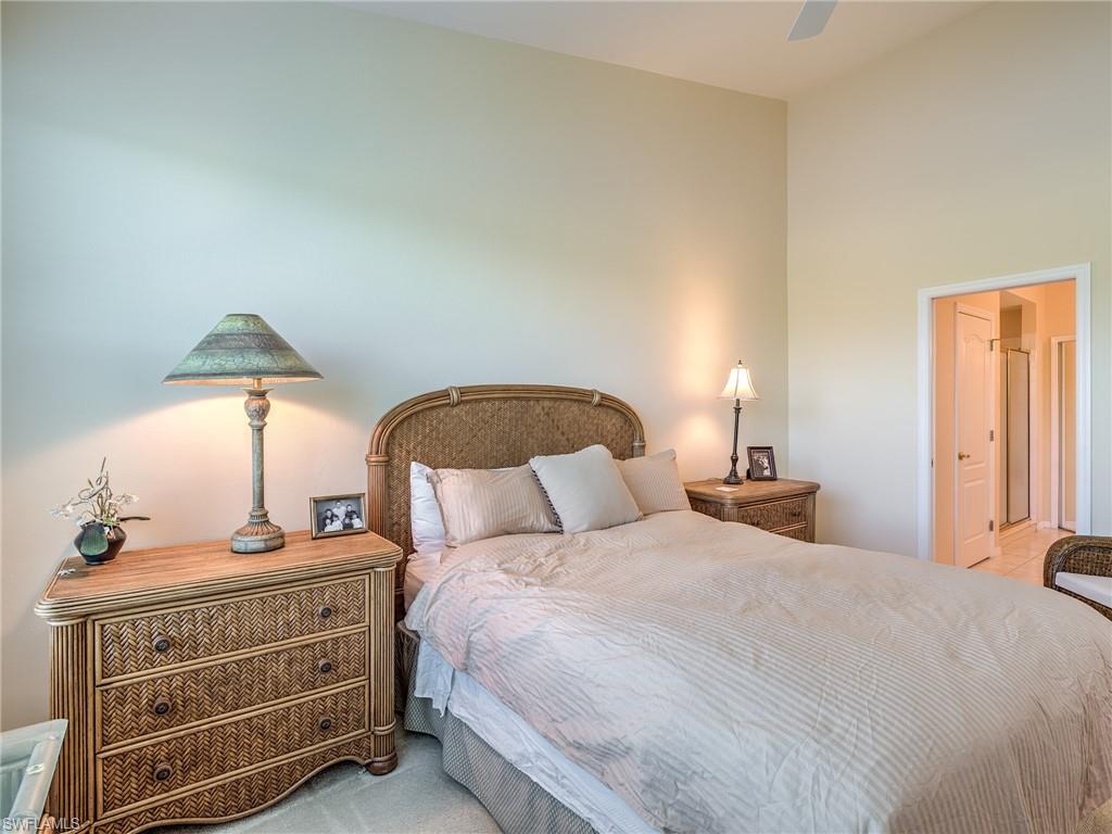 9830 Spring Run Boulevard, Unit 3408 Estero, FL 34135 - Photo 13 of 24 a bedroom with a bed a lamp and dresser