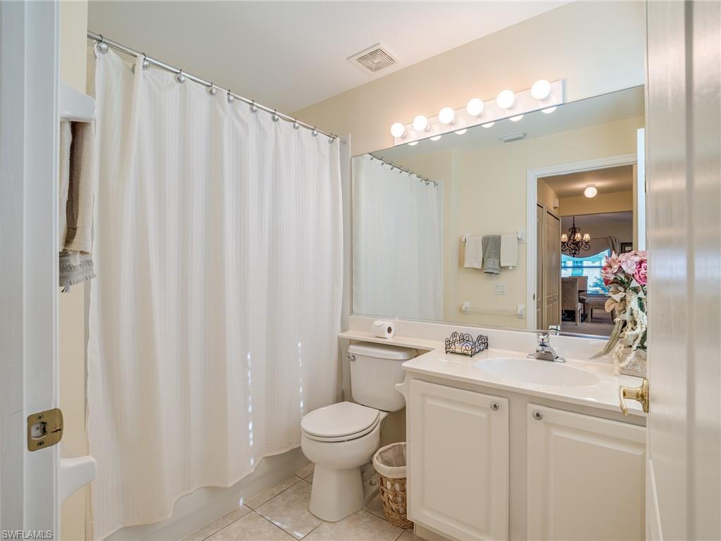 9830 Spring Run Boulevard, Unit 3408 Estero, FL 34135 - Photo 21 of 24 a bathroom with a toilet a sink and a mirror