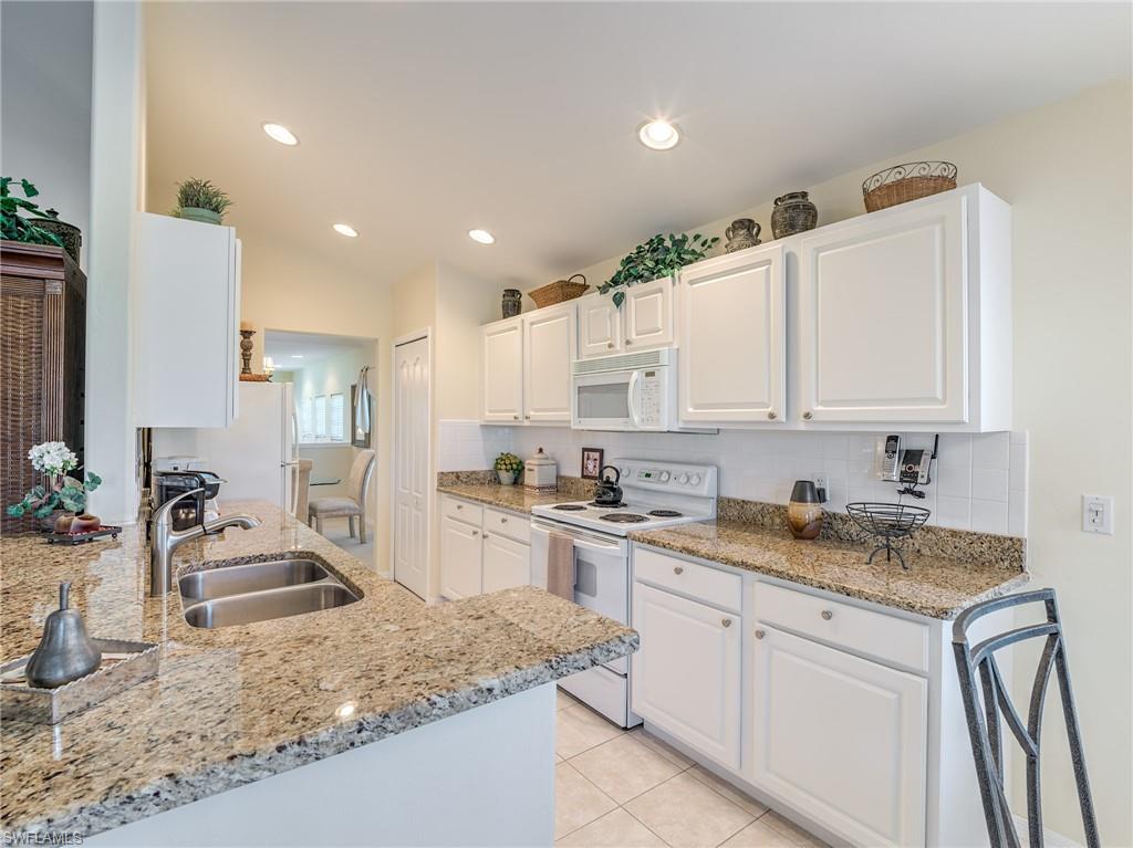9830 Spring Run Boulevard, Unit 3408 Estero, FL 34135 - Photo 7 of 24 a kitchen with a sink stove and cabinets