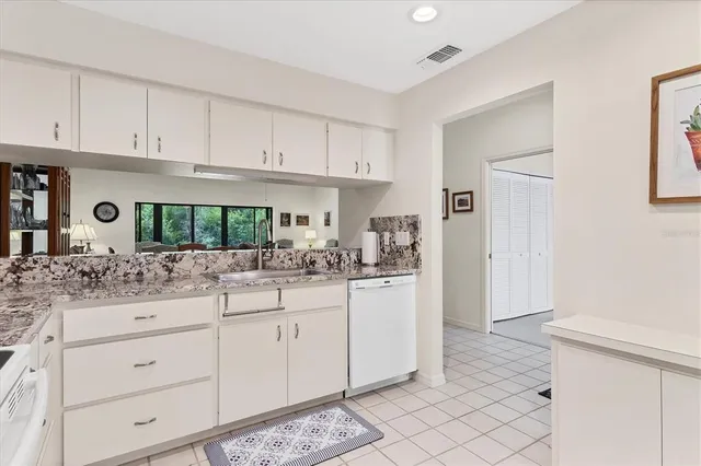 a kitchen with granite countertop white cabinets and white appliances