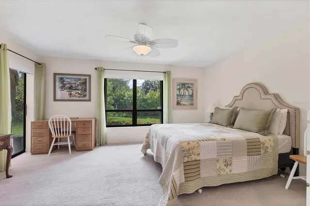 a bedroom with a bed chair and a large window