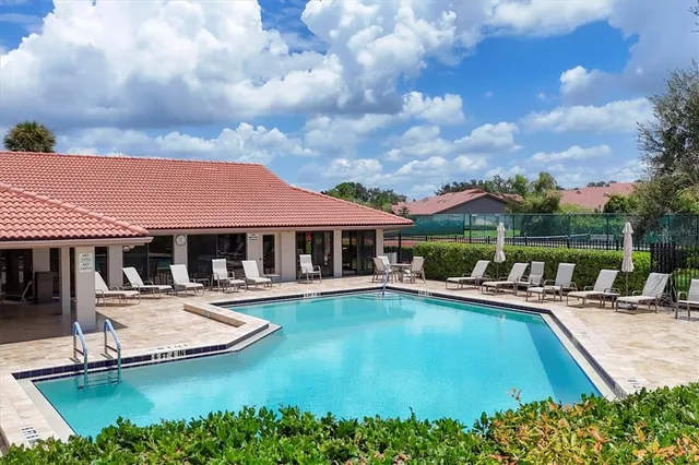 a view of a house with pool and chairs