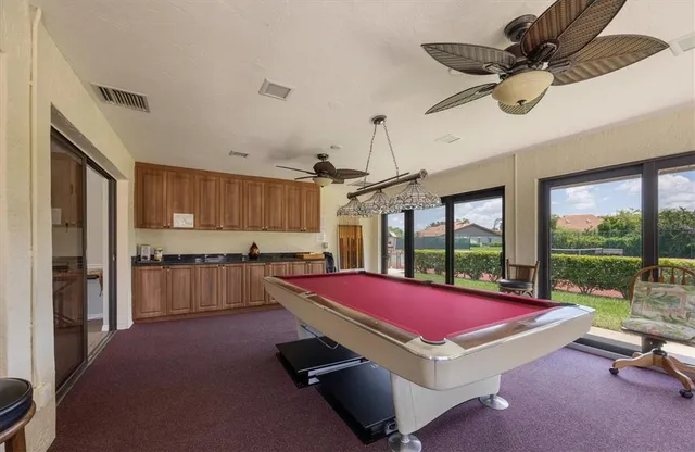 a room with pool table flat screen tv and outdoor view