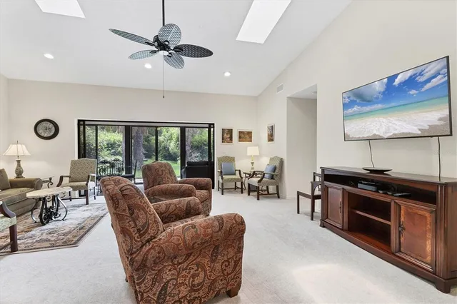 a living room with furniture a large window and a flat screen tv