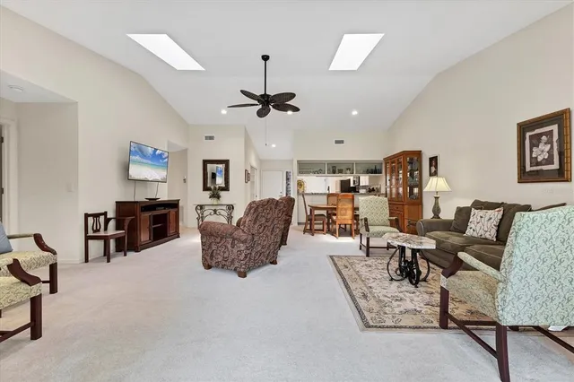 a living room with furniture kitchen view and a chandelier