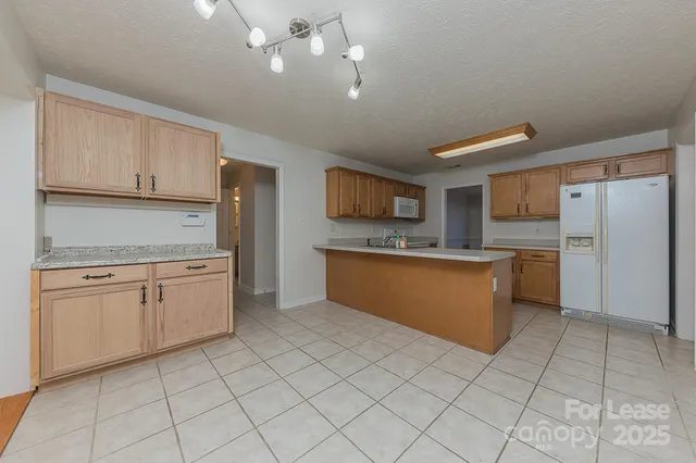 a kitchen with a refrigerator sink and cabinets