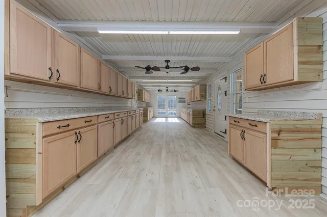 a kitchen with granite countertop a stove cabinets and wooden floor