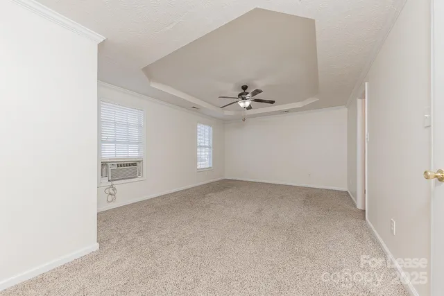 an empty room with windows and fan