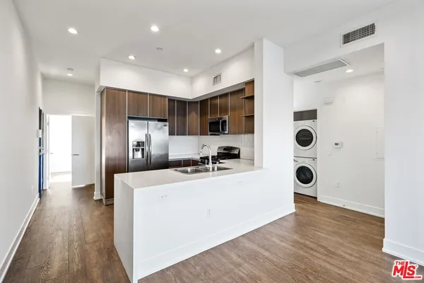 a kitchen with stainless steel appliances a refrigerator and a stove top oven