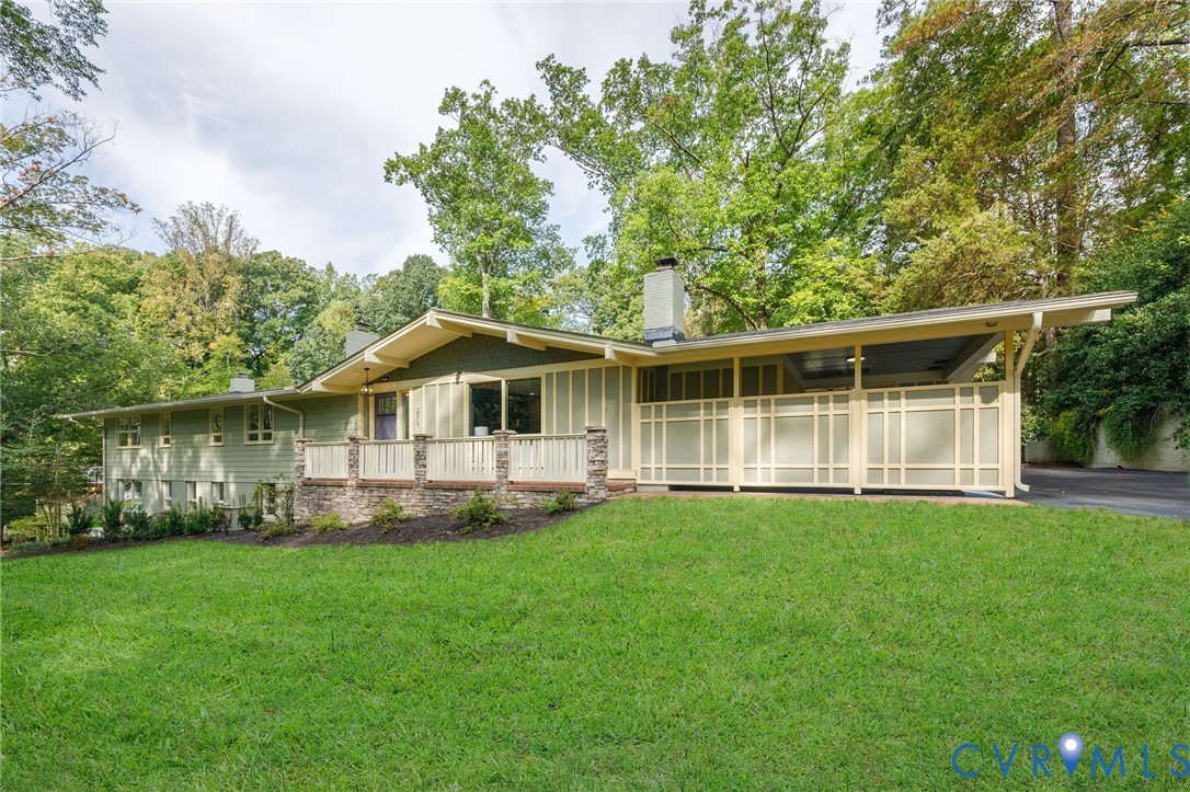 a front view of a house with a yard and trees