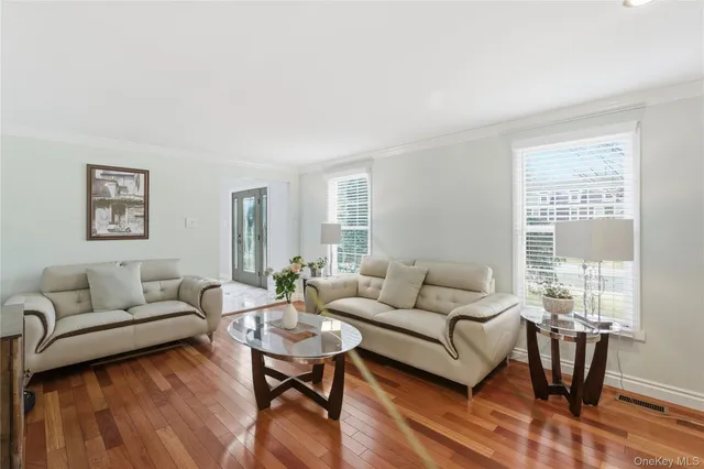 a living room with furniture wooden floor and a large window