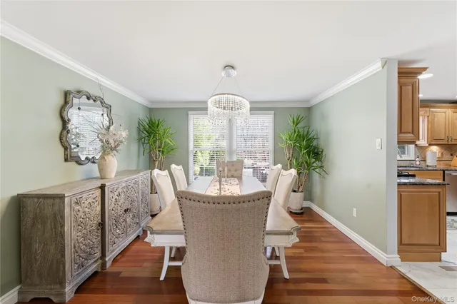 a dining room with furniture potted plants and wooden floor