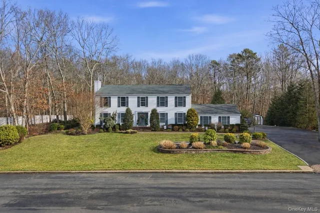 a view of a house with a big yard and large trees