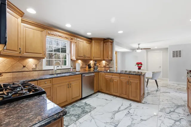 a kitchen with stainless steel appliances granite countertop a sink counter space and a window