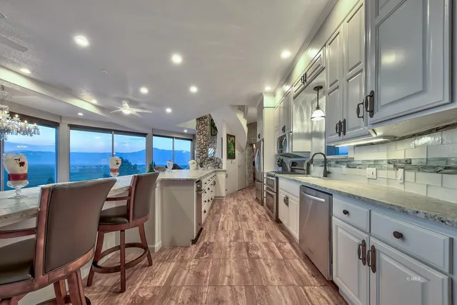 a kitchen with stainless steel appliances granite countertop a sink a stove and cabinets