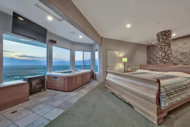 a spacious bedroom with a large bed and large windows