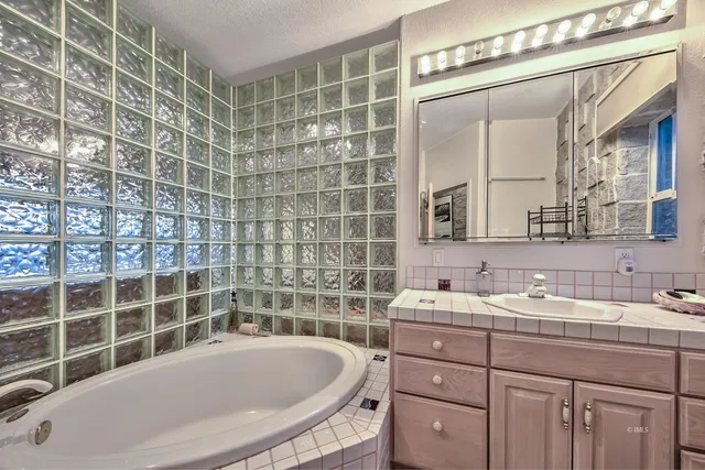 a bathroom with a tub sink and mirror