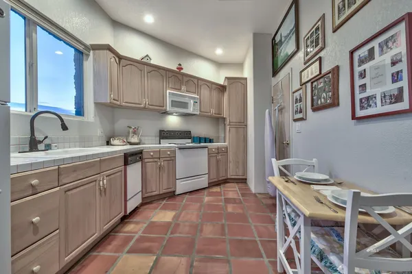 a kitchen with stainless steel appliances a table chairs in it and a window