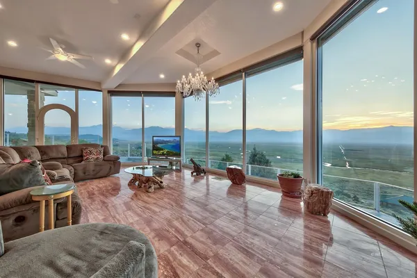 a living room with furniture and floor to ceiling windows