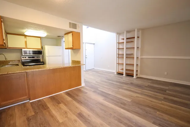 a view of a kitchen with wooden floor and electronic appliances
