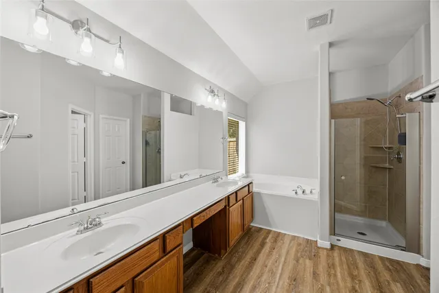 a spacious bathroom with a shower sink and mirror