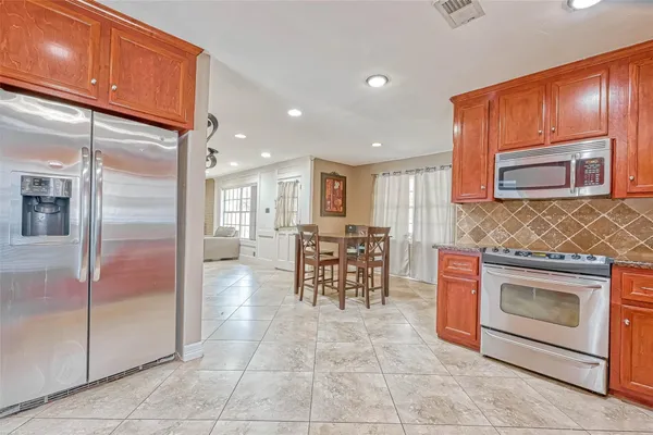 a kitchen with stainless steel appliances granite countertop a stove a sink and a microwave