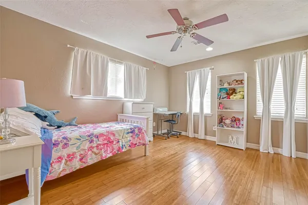 a bedroom with a bed and wooden floor