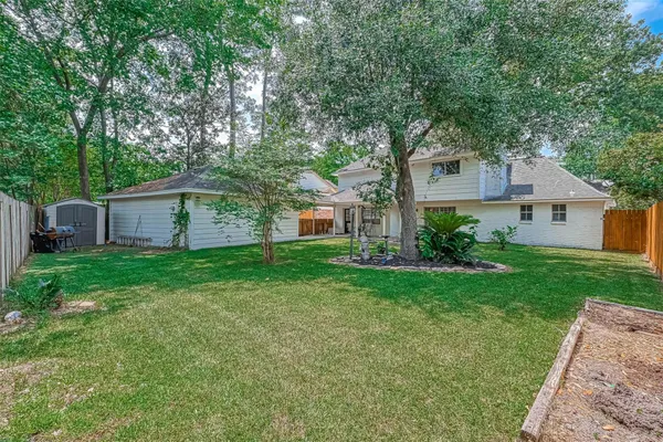 a view of a house with a yard potted plants and large tree