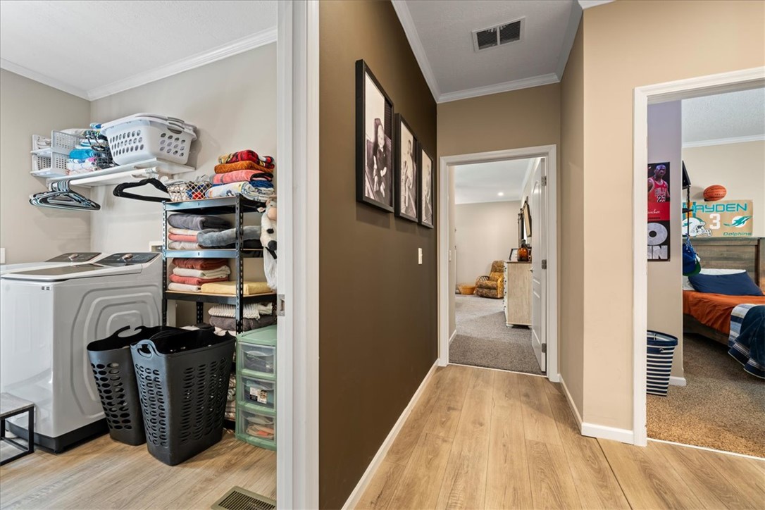 116 Parkview Road Iva, SC 29655 - Photo 33 of 44 Functional laundry nook adjacent to a hallway with sleek wood-look flooring.