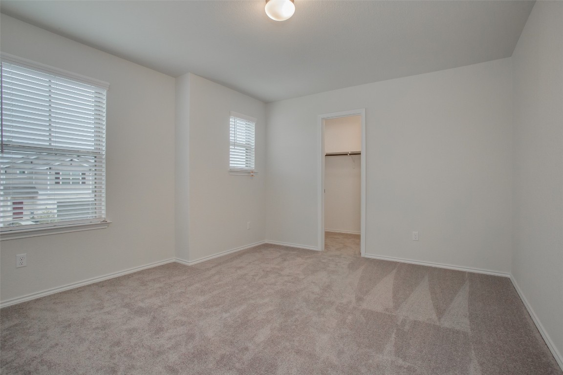 148 Spotted Rail Ridge Leander, TX 78641 - Photo 23 of 31 A spacious bedroom offers comfort, featuring a window for ample natural light and a convenient closet.