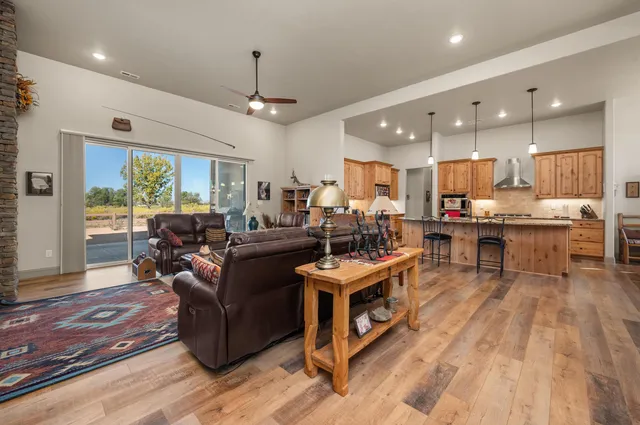 a living room with stainless steel appliances kitchen island granite countertop furniture wooden floor and a view of kitchen