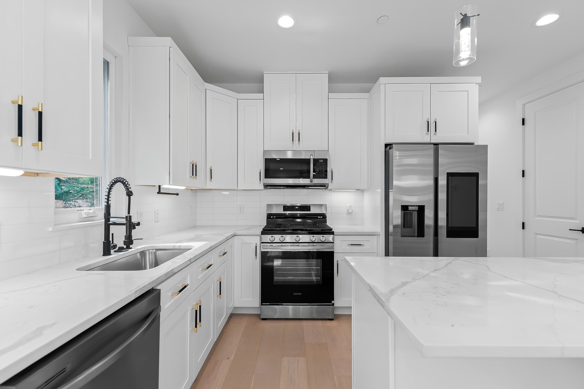 5305 Ledesma Road, Unit 4 Austin, TX 78721 - Photo 3 of 40 A pristine white kitchen features a large island and ample cabinetry, offering both functionality and aesthetic appeal.