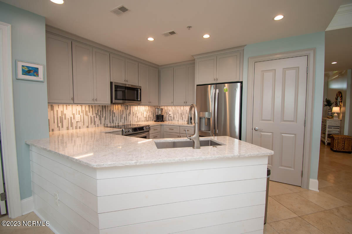 1435 Salter Path Road, Unit I 2 Indian Beach, NC 28512 - Photo 9 of 54 Shiplap detail was a part of the kitchen renovation in 2022. Gorgeous quartz counters and stainless farmhouse sink!