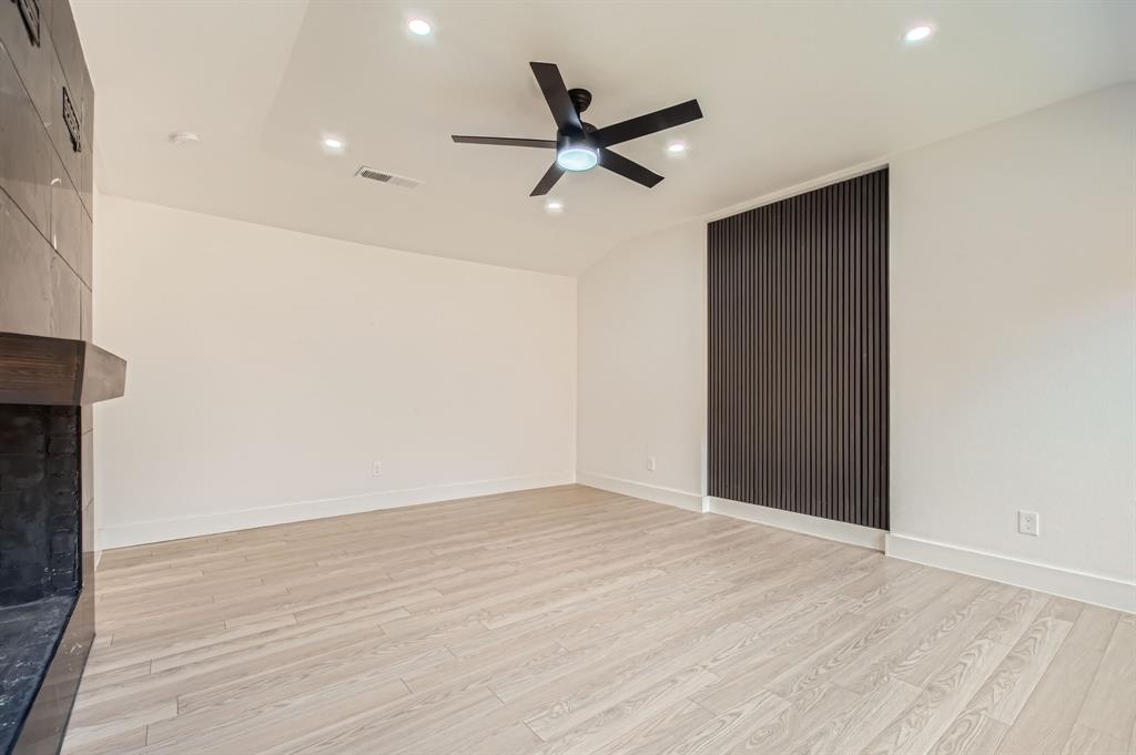 16212 Spring Creek Road Dallas, TX 75248 - Photo 17 of 28 an empty room with wooden floor and a ceiling fan