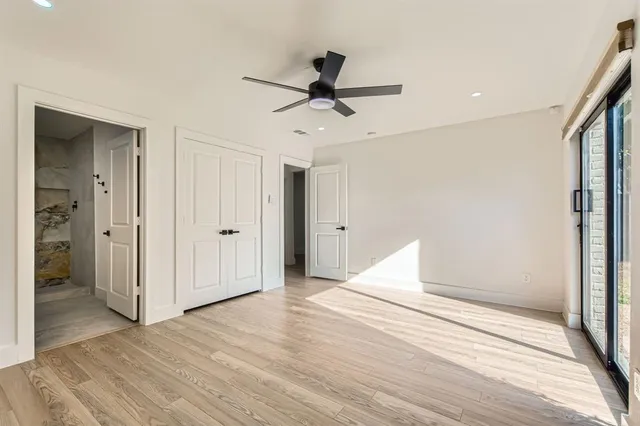 a view of a livingroom with wooden floor and a ceiling fan