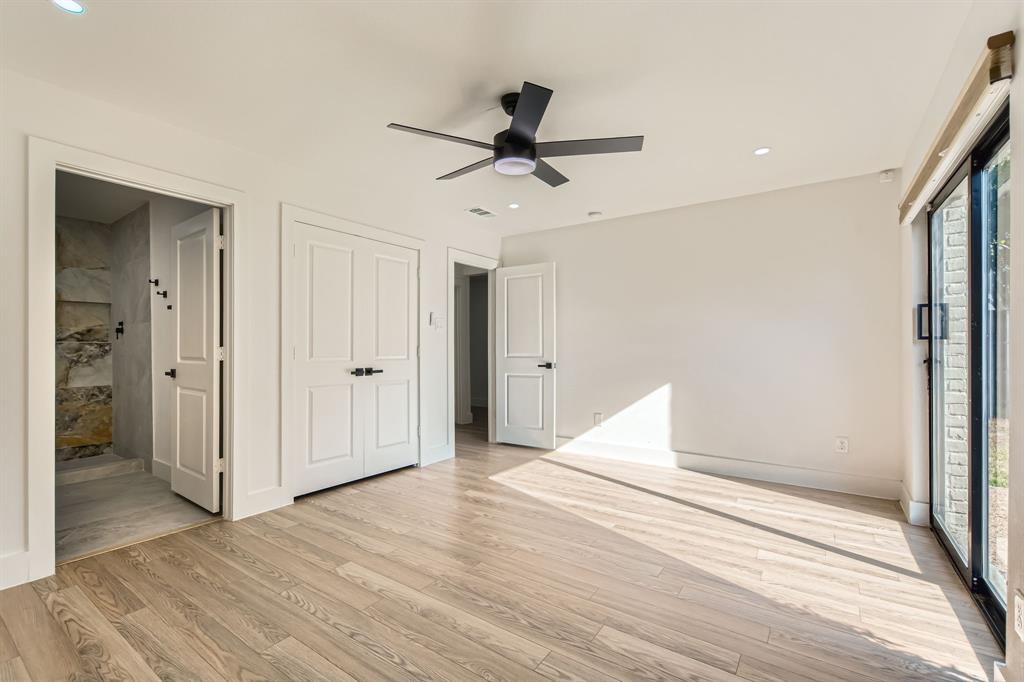 16212 Spring Creek Road Dallas, TX 75248 - Photo 21 of 28 a view of a livingroom with wooden floor and a ceiling fan