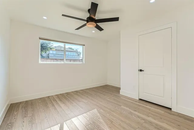 a view of room with hardwood floor and ceiling fan