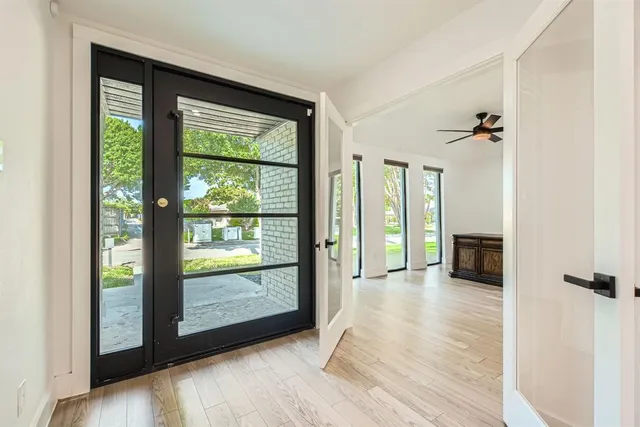 a view of a room with a large window and wooden floor
