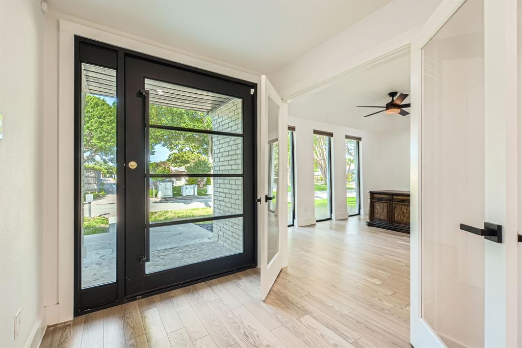 16212 Spring Creek Road Dallas, TX 75248 - Photo 4 of 28 a view of a room with a large window and wooden floor