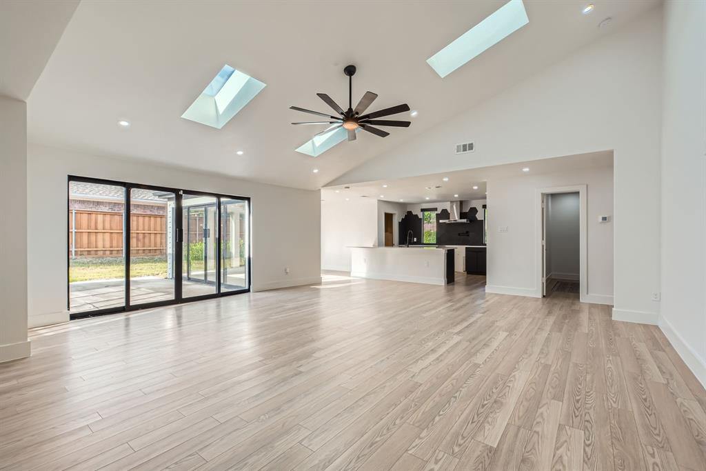 16212 Spring Creek Road Dallas, TX 75248 - Photo 6 of 28 a view of an empty room with wooden floor and a ceiling fan