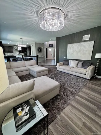 a living room with furniture and a chandelier